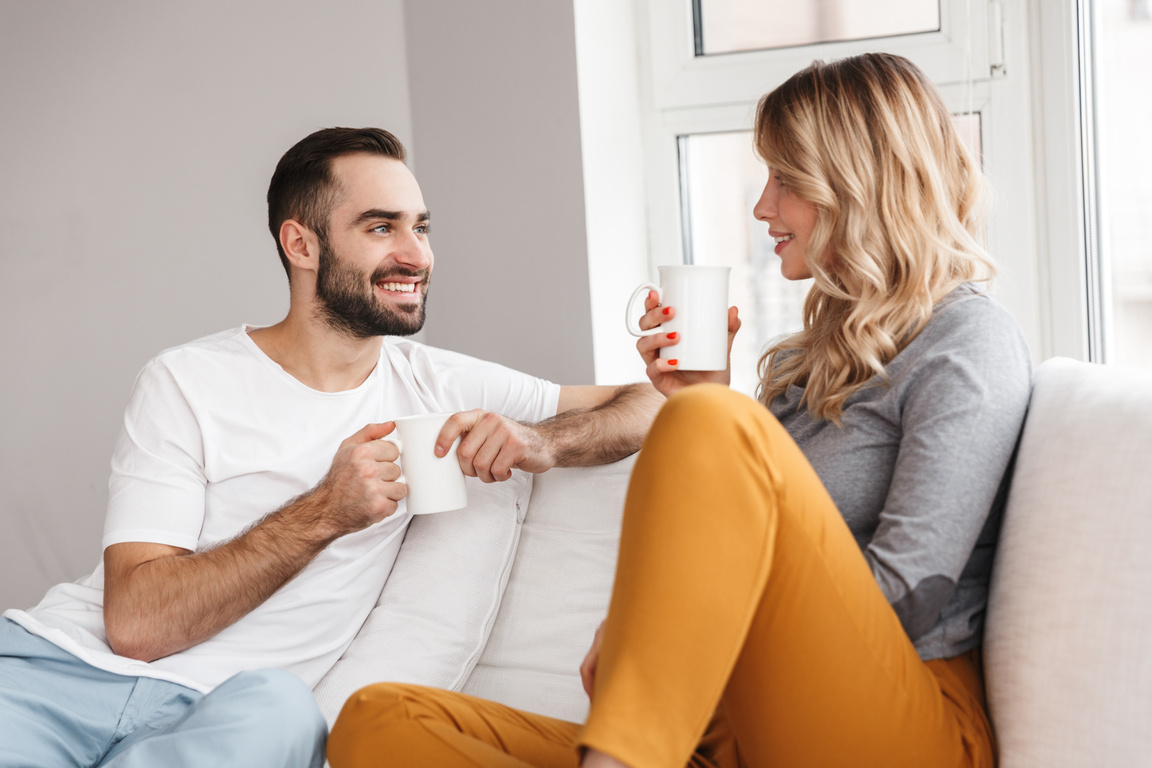 Couple Relaxing on the Couch Drinking Coffee