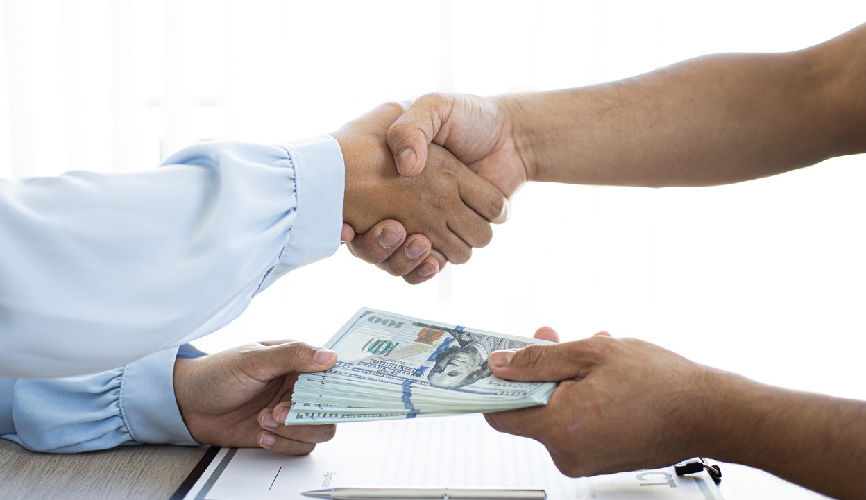 Businesspeople Giving Money and a Handshake